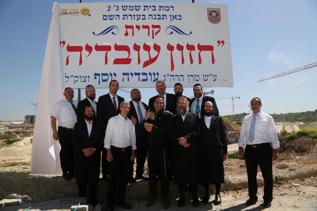 צילום קבוצתי על רקע השלט להקמת קריית חזון עובדיה 